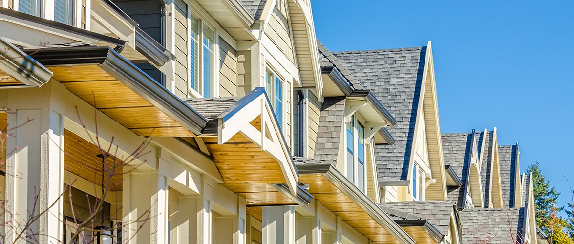 Warm-coloured town home fronts made of wood.