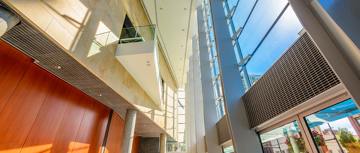 Large modern atrium with 100+ foot glass windows and overlooking interior balconies.