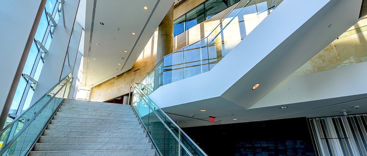 Grand white marble staircases weave inside a large modern atrium.